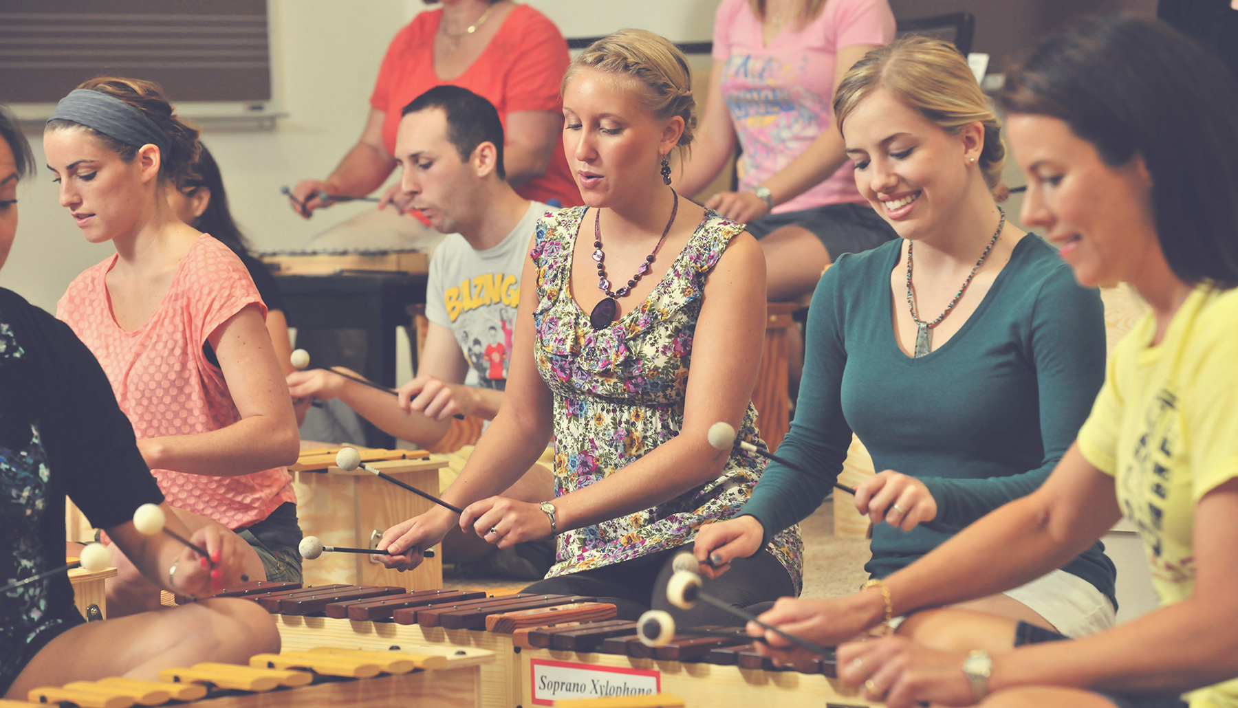 a group of people playing xylophones while seated on the floor