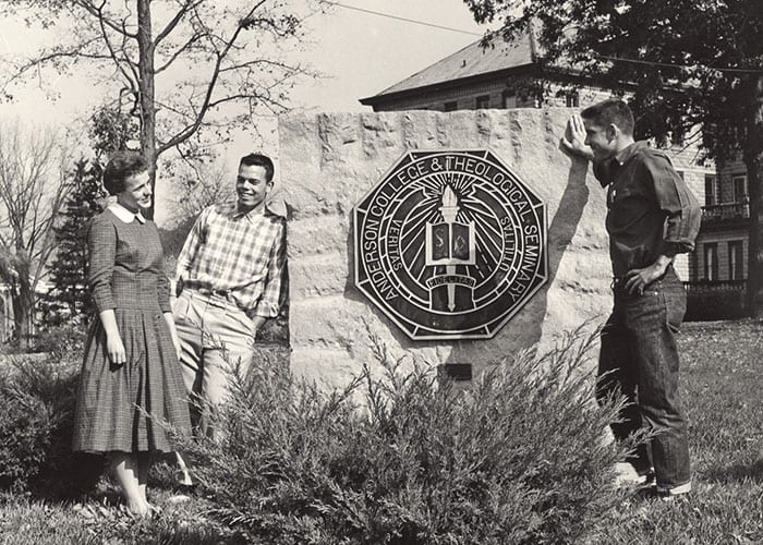 Old AU seal outside with students gathered around it.