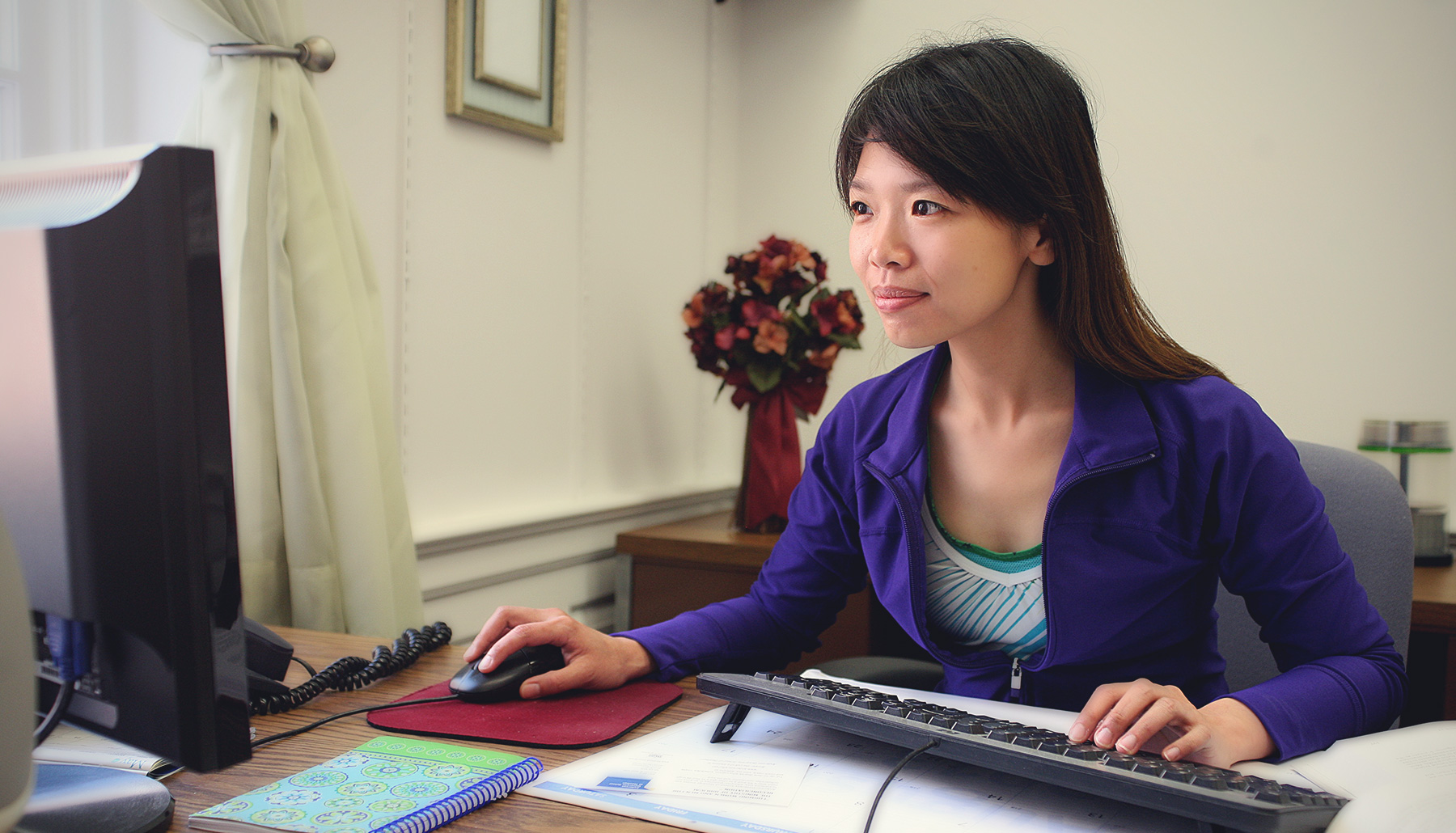 a young woman works at a computer