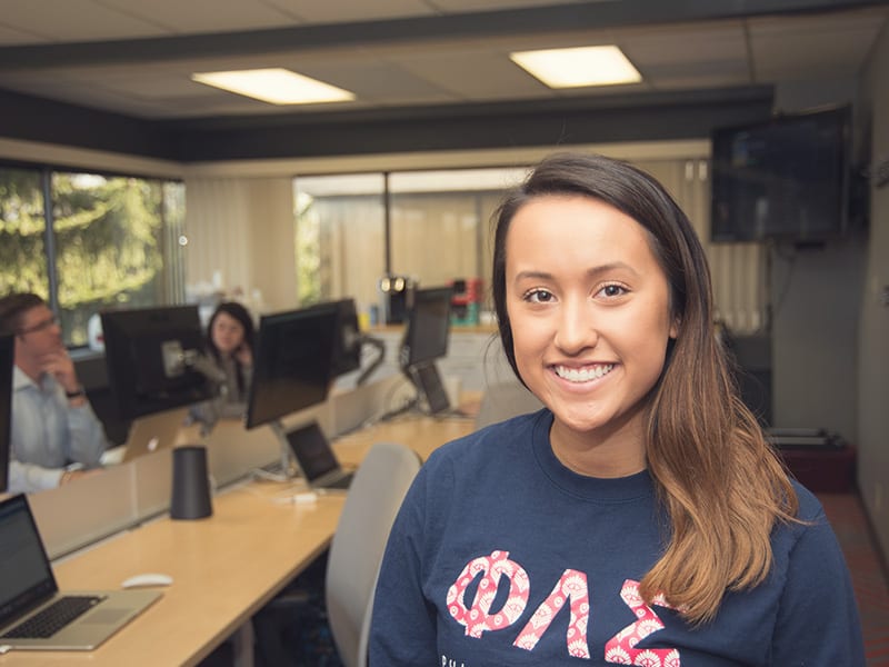 student worker posing at her job in the computer lab
